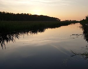 Rustgevende zonsondergang over het water nabij Vakantiehuis in Oudesluis, Noord-Holland.