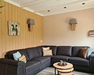 Comfortabele zithoek in Huisje in Oudesluis, vakantiehuis in Noord-Holland met hoekbank en houten tafels.