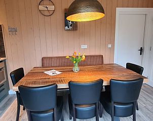 Gezellige eetkamer in Huisje in Oudesluis, vakantiehuis in Noord-Holland met houten interieur en hanglamp.