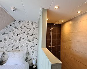 Stijlvolle badkamer in Huisje in Oudesluis, vakantiehuis in Noord-Holland met moderne douche en tegelwerk.