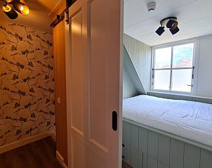 Slaapkamer in Huisje in Oudesluis, vakantiehuis in Noord-Holland met licht interieur en comfortabel bed.