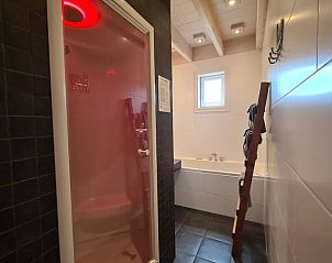 Moderne badkamer met douche en bad in Vakantiehuisje in Oudesluis, ideaal voor ontspanning in Noord-Holland.