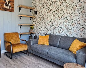 Gezellige zithoek met bloemenbehang in Vakantiehuis in Oudesluis, Noord-Holland, voor een ontspannen verblijf.