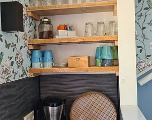 Praktische keukenopslag in Vakantiehuis in Oudesluis, Noord-Holland, met planken en servies voor comfort.