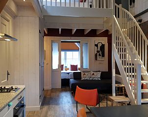 Ruime woonkamer met trap in Huisje in Oudesluis, vakantiehuis in Noord-Holland.