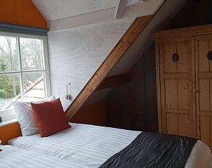 Gezellige slaapkamer met houten kast in Huisje in Oudesluis, vakantiehuis in Noord-Holland.