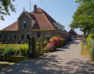 Ingang van Huisje in Oudesluis, vakantiehuis in Noord-Holland met kleurrijke bloemen.