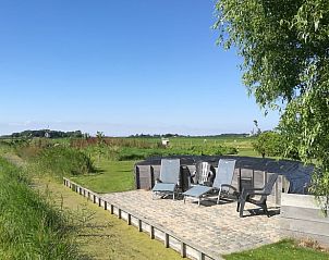 Rustige tuin met ligstoelen bij Huisje in Oudesluis, vakantiehuis in Noord-Holland.