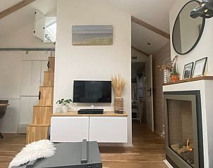 Gezellige woonkamer in Huisje in Schoorl, vakantiehuis in Noord-Holland met moderne inrichting en sfeervolle open haard.