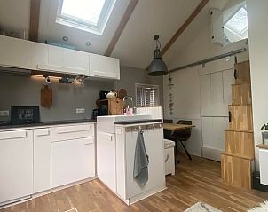 Gezellige keuken van Huisje in Schoorl, vakantiehuis in Noord-Holland, met moderne inrichting en houten details voor een knusse sfeer.