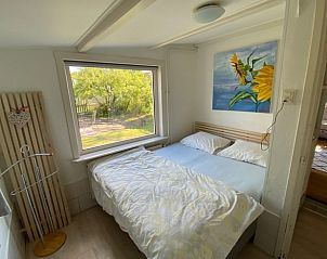 Comfortabele slaapkamer in Vakantiehuisje in Schoorl, Noord-Holland met uitzicht op de tuin.