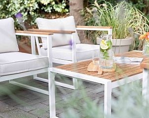 Gezellige open haard in de woonkamer van Huisje in Schoorl, Noord-Holland noord.