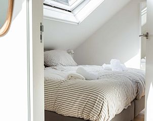 Lichte slaapkamer met dakraam in vakantiehuis Huisje in Schoorl, Noord-Holland noord.