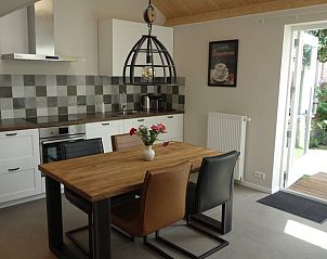 Gezellige keuken en eetruimte in Huisje in Schoorl, vakantiehuis in Schoorl, Noord-Holland, met moderne inrichting en uitzicht op de tuin.