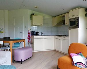 Cozy indoor area of Holiday Home in Schoorl, North Holland, with modern kitchen and cozy sitting area.