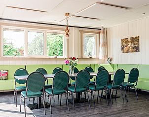 Binnenruimte van De Gouwe Droom in Bovenkarspel met gezellige eetruimte en groene accenten, perfect voor een familievakantie aan de IJsselmeerkust.