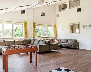 Ruime woonkamer met tafelvoetbal in De Gouwe Droom, Bovenkarspel, ideaal voor ontspanning en spelplezier aan de IJsselmeerkust, Noord-Holland.