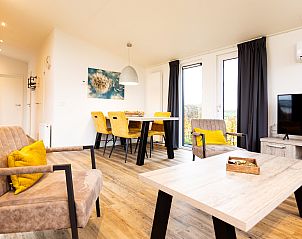 Gezellige woonkamer van Waterlodge, een vakantiehuis in Berkhout, Noord-Holland, met moderne inrichting en uitzicht op de groene omgeving.