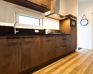 Moderne keuken in Waterlodge vakantiehuis, Berkhout, Noord-Holland, met stijlvolle houten afwerking en luxe apparatuur.