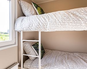 Gezellige slaapkamer met stapelbed in vakantiehuis Leijhoeve voor 5 personen, Berkhout, Noord-Holland, met uitzicht op de natuurlijke omgeving.