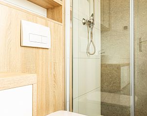 Modern bathroom in Module Flat Roof 4 persons, vacation home in Berkhout, North Holland, with glass shower and wooden accents.