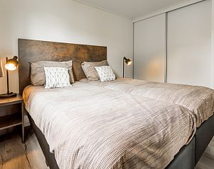 Comfortable bedroom in vacation home Parel 5 persons in Berkhout, North Holland, with modern furnishings and atmospheric lighting.