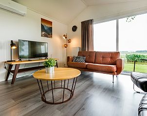 Cozy living room of vacation home Parel 5 persons in Berkhout, North Holland, with a view of the green surroundings.