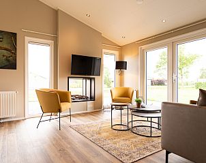 Stylish living room of the Leijhoeve vacation home for 6 people in Berkhout, North Holland, with modern interior and garden view.