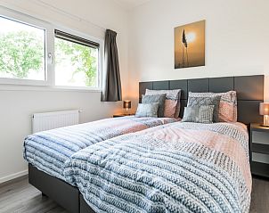 Cozy bedroom in Module 5-person vacation home, Berkhout, North Holland, with comfortable beds and peaceful views of nature.