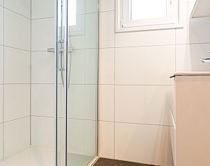 Modern bathroom in Module Special 6-person vacation home, Berkhout, North Holland, with glass shower enclosure and stylish sink.