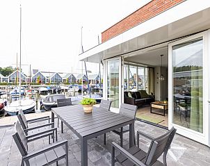 Geniet van het terras van Lakehouse I in Uitgeest, Noord-Holland, met uitzicht op de jachthaven en comfortabele binnenruimte in dit vakantiehuis.