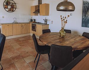 Gezellige keuken en eetruimte in Westergeest vakantiehuis, Uitgeest, Noord-Holland met houten interieur en moderne voorzieningen.