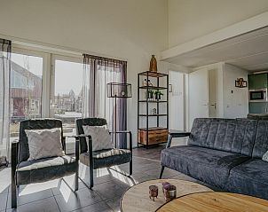 Cozy living room of Het Kraaijennest Miva vacation home in Uitgeest, North Holland, with lots of natural light and modern furnishings.