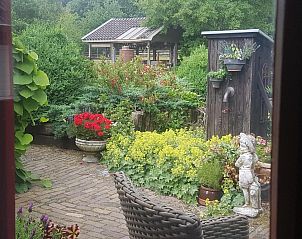 Rustieke tuin bij B&B Het Bakhuis in Loenen, Veluwe met beeld en bloemen.