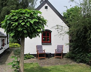 Buitenzitje bij B&B Het Bakhuis in Loenen, Veluwe omgeven door groen.