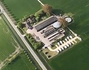 Dronefoto van de locatie van Huisje in Zuid-Scharwoude, een vakantiehuis in Noord-Holland, met uitgestrekte groene velden.
