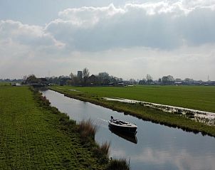 Rustige vaart met een boot bij Vakantiehuisje in Broek in Waterland, omringd door natuur in Amsterdam eo, Noord-Holland.