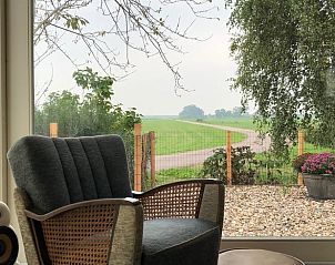 Comfortabele stoel met uitzicht op het landschap bij Vakantiehuis in Broek in Waterland, Amsterdam eo, Noord-Holland.