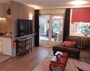 Gezellige woonkamer in Vakantiehuis in Nutter, Twente, met comfortabele bank en toegang tot terras.