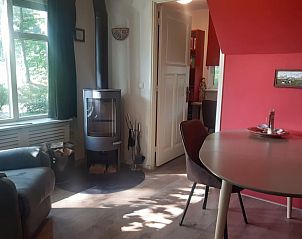Knusse hoek met open haard in Vakantiehuis in Nutter, Twente, voor warme avonden in de natuur.