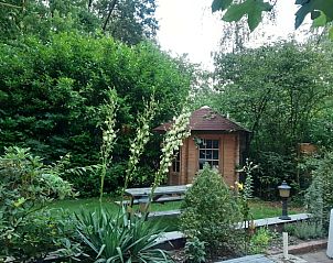 Prachtige tuin met houten tuinhuis bij Vakantiehuis in Nutter, Twente, omringd door groen.