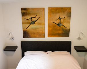 Slaapkamer van Huisje in Nutter, vakantieverblijf in Nutter, met kunst aan de muur en een knus bed.