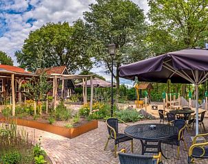 Vakantiehuis in Nutter, gezellig terras bij vakantiehuis in Twente, Overijssel, met parasols en zitplaatsen.