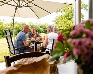 Gezellig samenzijn op de veranda van vakantiehuis Huisje in Den Ham in Twente, Overijssel.