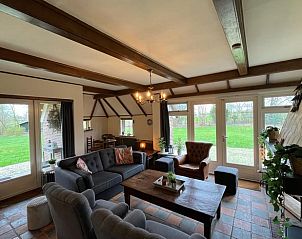 Gezellige woonkamer in Vakantiehuis in Den Ham, met uitzicht op de tuin.