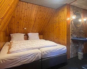 Slaapkamer met houten interieur in Vakantiehuis in Den Ham, Overijssel.