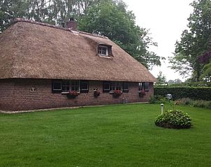 Zijaanzicht van Vakantiehuis in Den Ham, met bloeiende tuin in Twente.