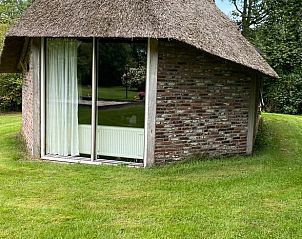 Rustiek vakantiehuisje in Den Ham, Twente, met rieten dak en uitzicht op groene omgeving, een serene plek in Overijssel.