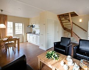 Comfortabele woonkamer in Vakantiehuis in Wierden, Twente met open keuken en houten trap.