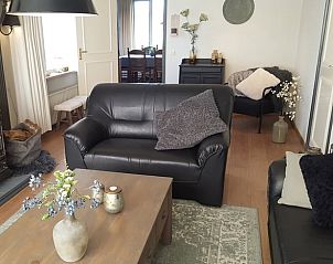 Gezellige woonkamer in vakantiehuis Hezingen, Twente, met moderne inrichting en houtkachel.